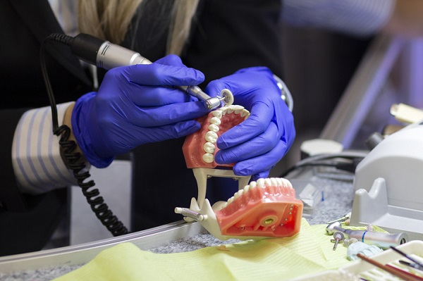 Dental technician working on a pair of dentures.