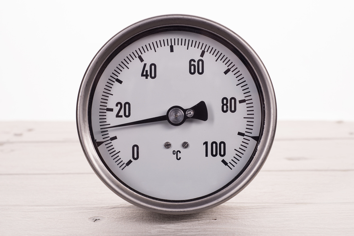 dial gauge thermometer on a white wooden background